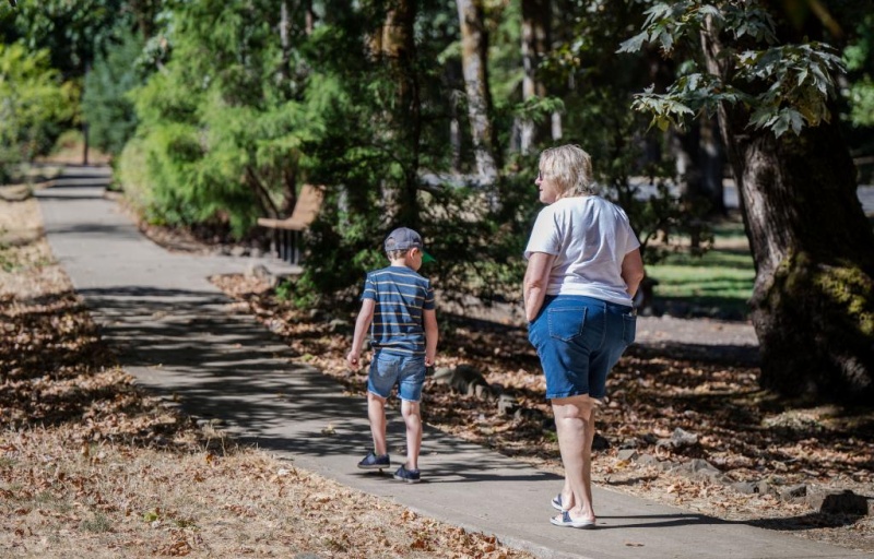 A child and an adult walking away down the TRACK Trail while looking around