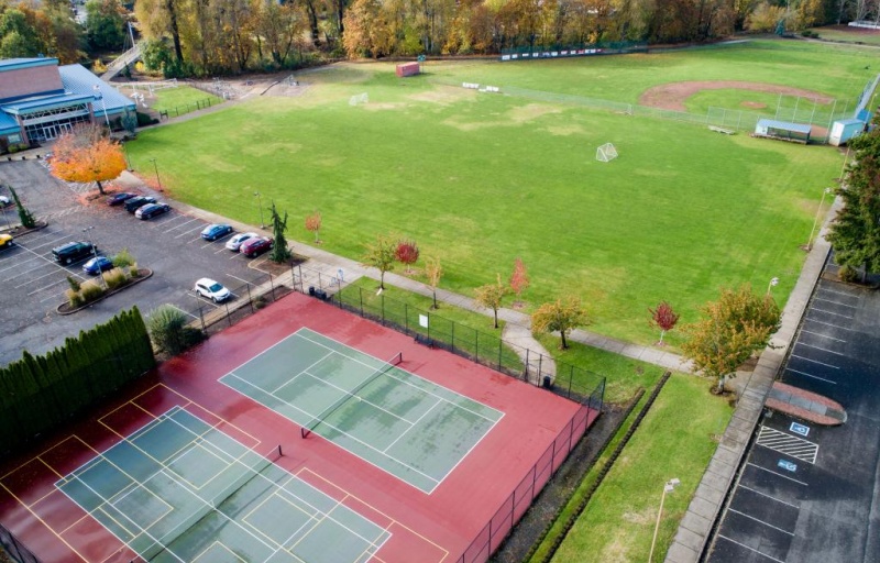 An aeriel view of the park, featuring tennis courts and a field