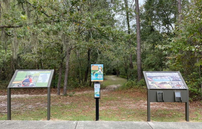 the Moores Creek Fishing sign amongst other park signs